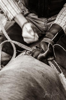 Bull rider hitting his hands to tighten his grip on the rope.
