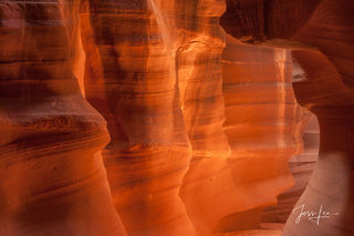 Warm reflected light illuminates the curved orange and red sandstone walls inside Antelope Canyon, Arizona.