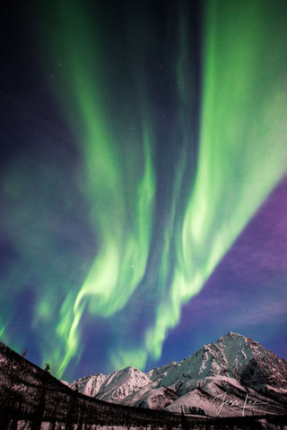 Aurora Borealis dancing over an Alaskan mountain range