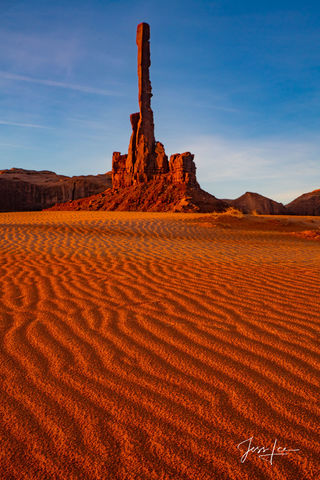 Picture of Totem Pole Rock in Arizona, with dunes in the foreground.