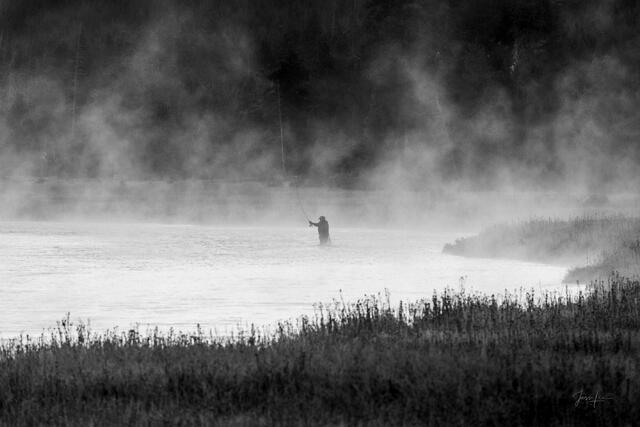Black and white silhouette of lone fly fisher casting in geothermal mist on the Madison River, Yellowstone — fine art print by Jess Lee
