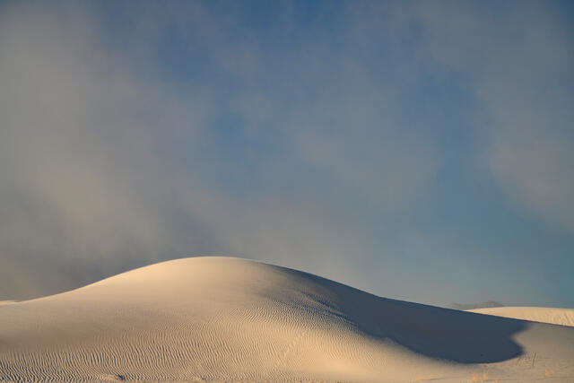 Fine art landscape photography of expansive white gypsum sand dunes at White Sands National Park, New Mexico, featuring minimalist ridges, soft natural light.
