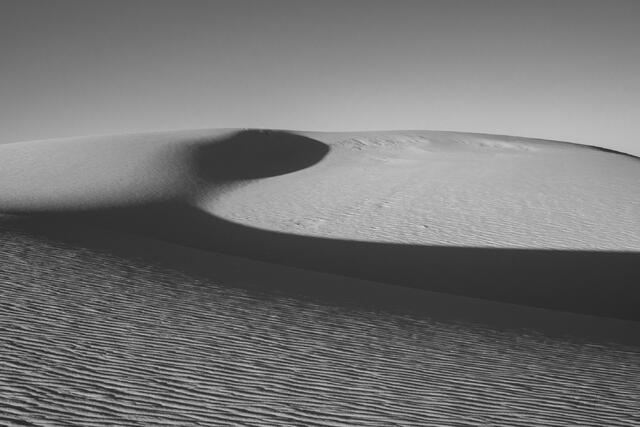 Luxury wall art of the New Mexico desert. A wide-angle landscape photograph showcasing the pristine, wind-sculpted white dunes and the vast horizon.
