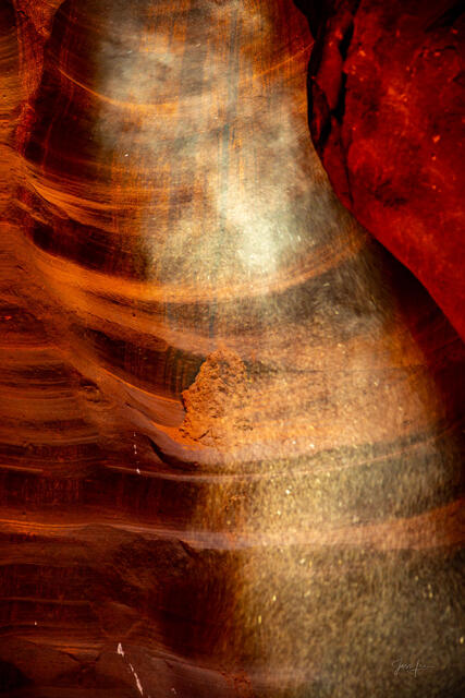 Veil of Light, Antelope Canyon - drifting sand suspended in a sunbeam against deep red sandstone