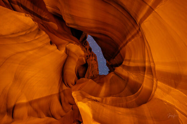 Sentinel of Stars, Antelope Canyon - star-filled night sky visible through a narrow opening framed by glowing amber sandstone walls
