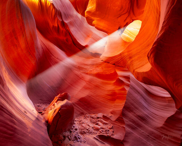 Crossing Light, Antelope Canyon - two diagonal sunbeams crossing inside a glowing red and orange sandstone chamber