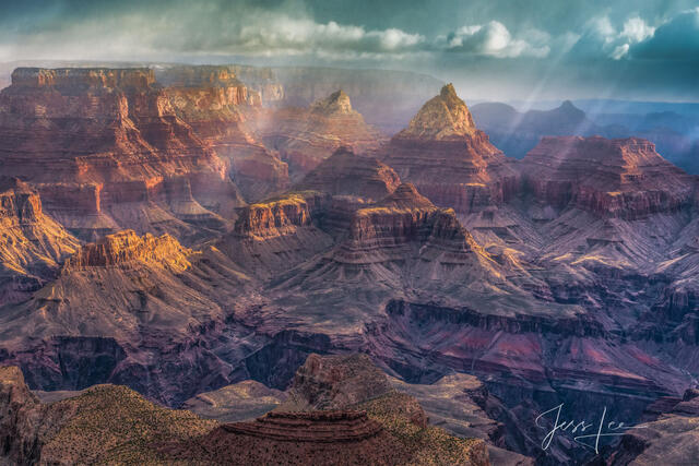 Sun breaking through storm clouds over the Grand Canyon in Red Rocks Country, Arizona. 