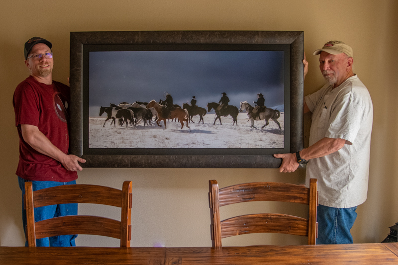 Jess Lee placing a new print in a clients home.