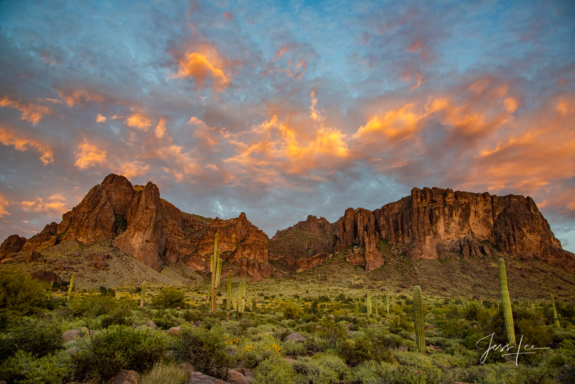 Photo of Cotton candy clouds hanging above a canyon in Monument Valley, Arizona.