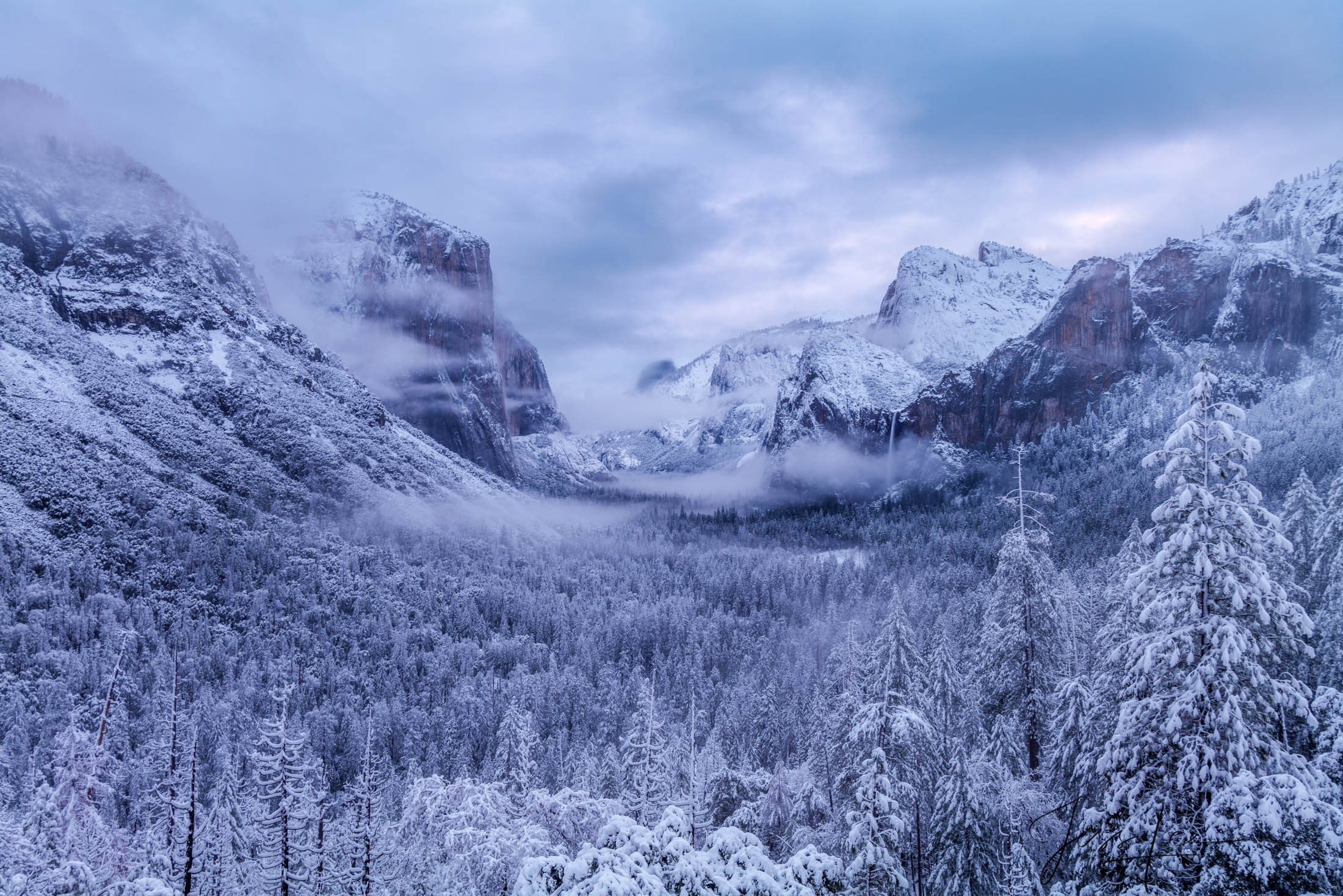 Tunnel View of Yosemite Valley Winter Blues An pristine early winter morning in Yosemite National Park, where the soft blue light of dawn illuminates a fresh blanket of...
