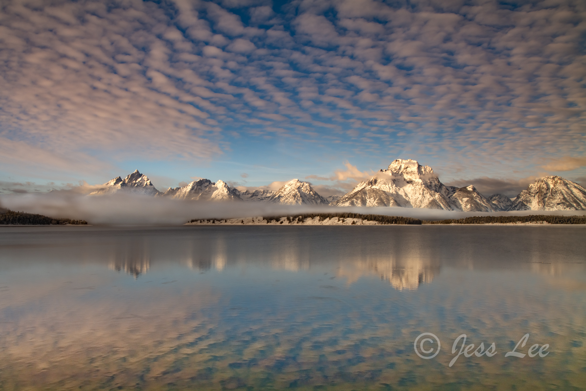 Jackson Lake and snow capped teton mountain range with reflection.