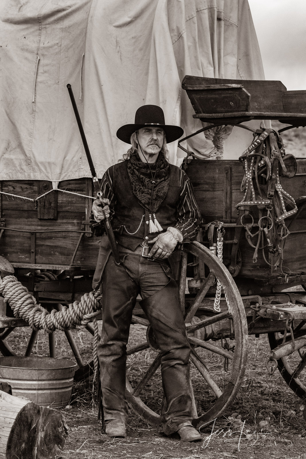 Cowboy, Plainsman At his covered wagon Old Time Cowboy Black and White Sepia Print. Plainsman with Henry Rifle at his covered wagon