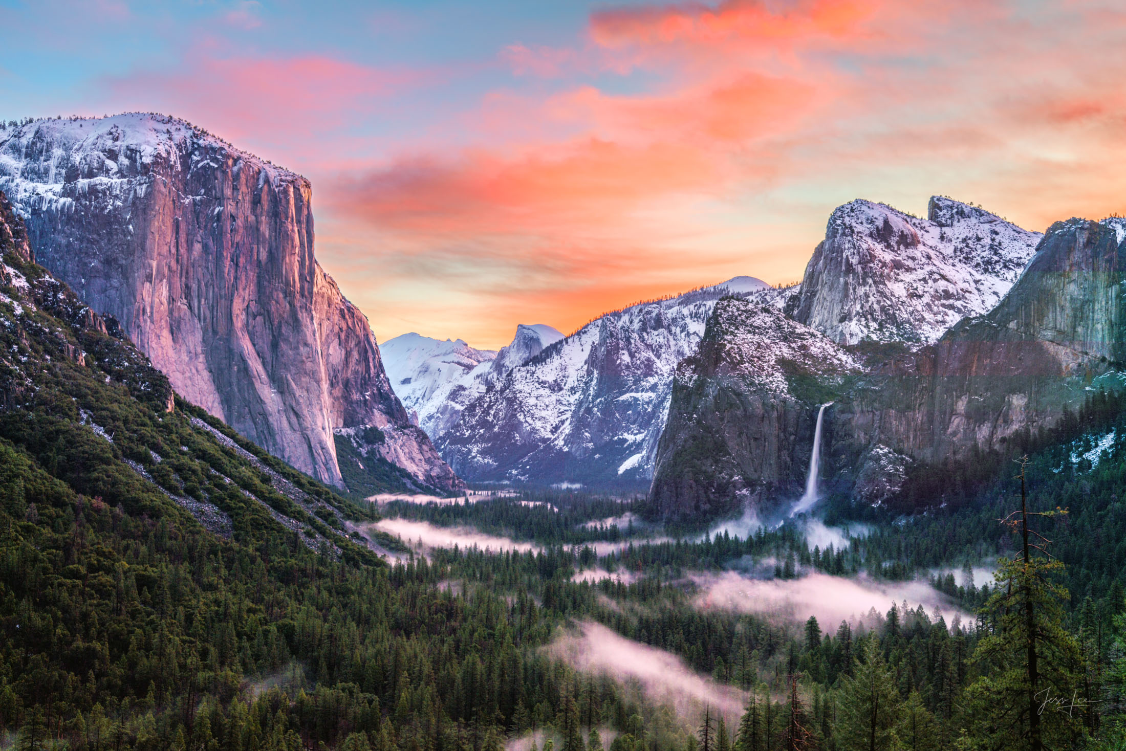 Yosemite National Park from the iconic Tunnel View. The early morning light gently kisses the snow-capped peaks, casting a warm glow that contrasts beautifully